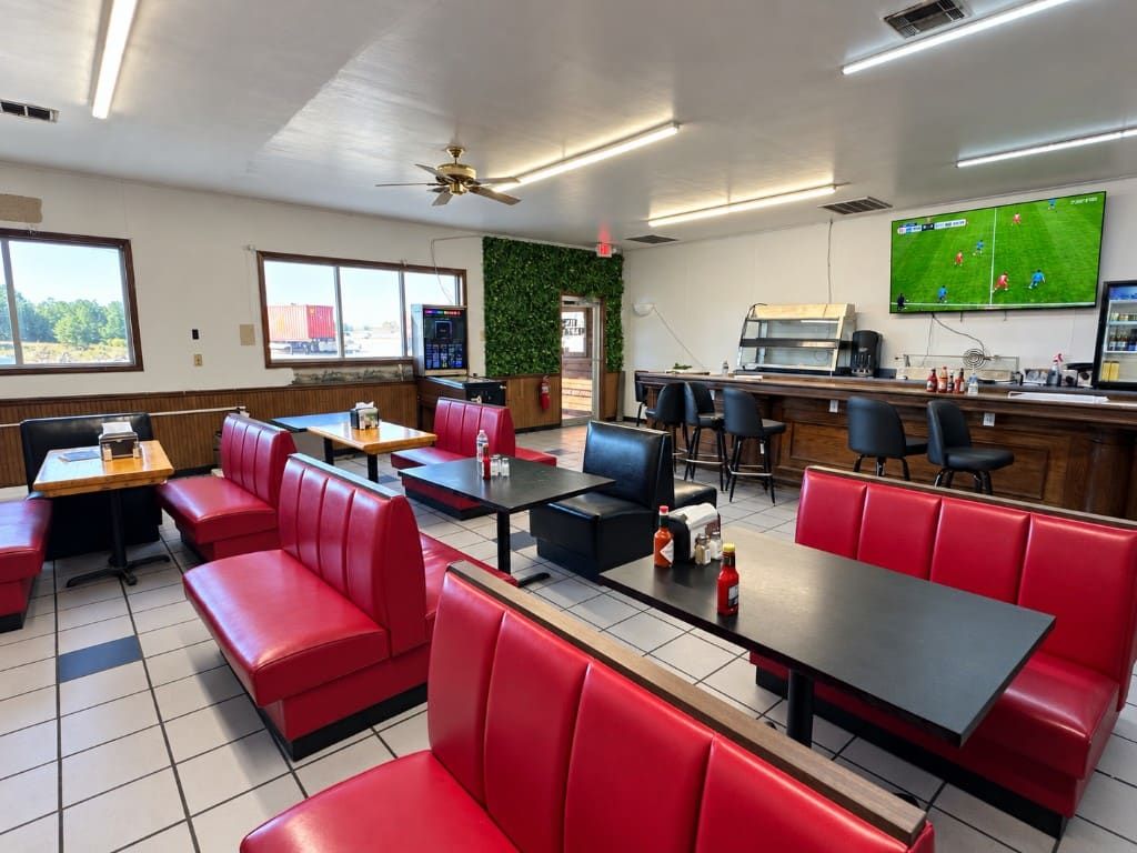 Red booths, the bar, and a TV in the Hillview dining room