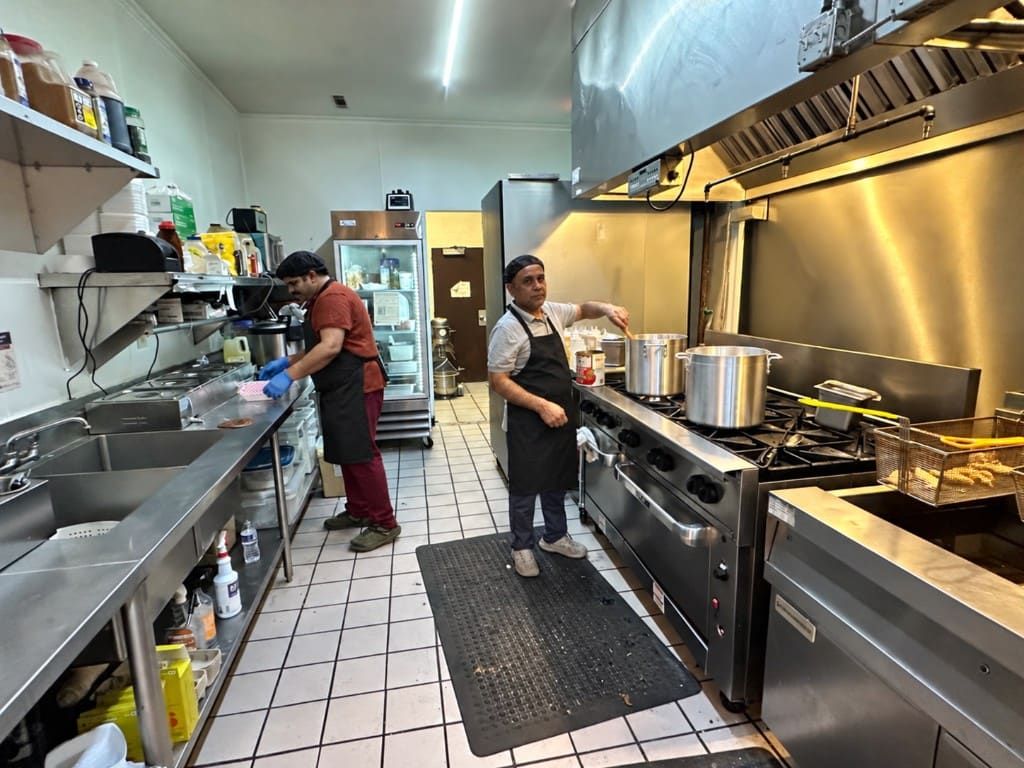 Two cooks working at the stove and prep line in the Hillview kitchen